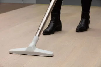 Personne passant l'aspirateur sur un plancher de bois